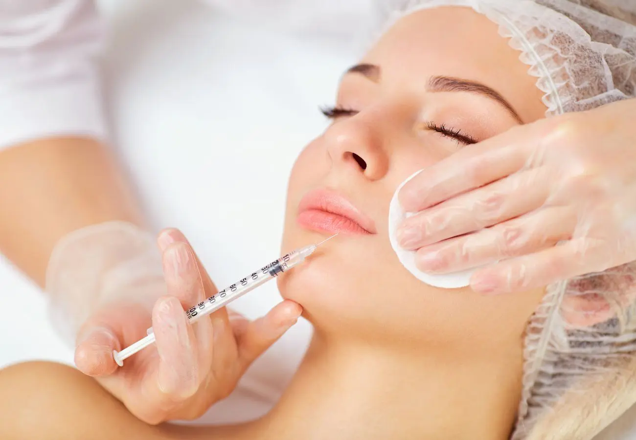 Closeup of woman's face with a syringe about to receive lip injections
