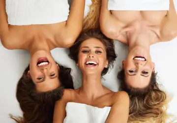 Group of three woman at a medical spa smiling after receiving aesthetic treatments