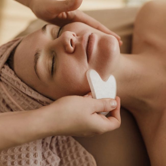 Woman at a medical spa having her face treated with body contouring